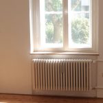 Spacious empty room with wooden floor and large window in Berlin, ideal for interior planning.