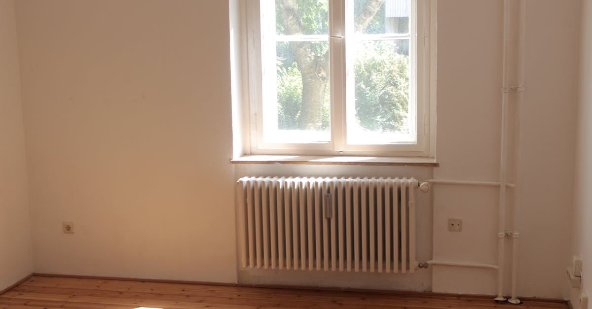 Spacious empty room with wooden floor and large window in Berlin, ideal for interior planning.