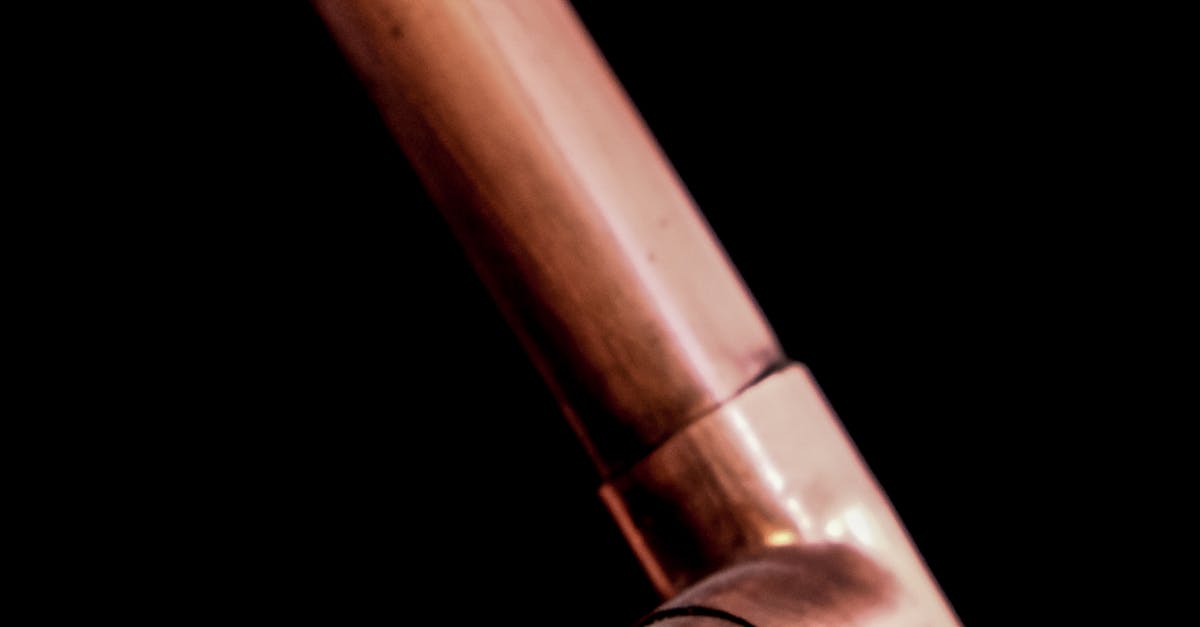 Industrial copper pipes close-up with a dark background, highlighting metallic textures.